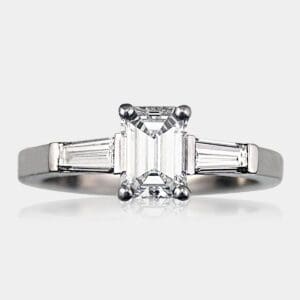 Handmade three-stone emerald cut diamond engagement ring with tapered baguette diamonds in 18ct white gold.