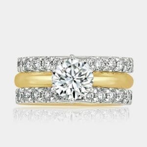 Round brilliant cut engagement and pair of gold wedding rings.