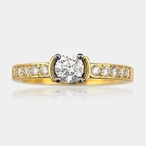 Handmade round brilliant cut diamond engagement ring with 18ct white gold four claw seting and bead set diamonds in 18ct yellow gold band.