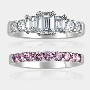 3 stone emerald cut diamond ring with round brilliant cut shoulder diamonds and matching pink diamond wedding ring.