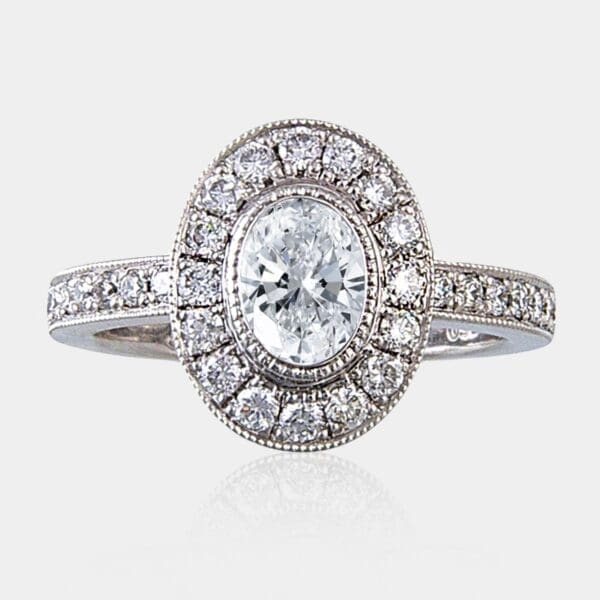 0.60 carat Oval diamond ring with surround and shoulder diamonds.