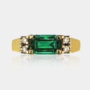 Handmade dress ring featuring emerald cut green emerald and round brilliant cut diamonds in 18ct yellow gold.