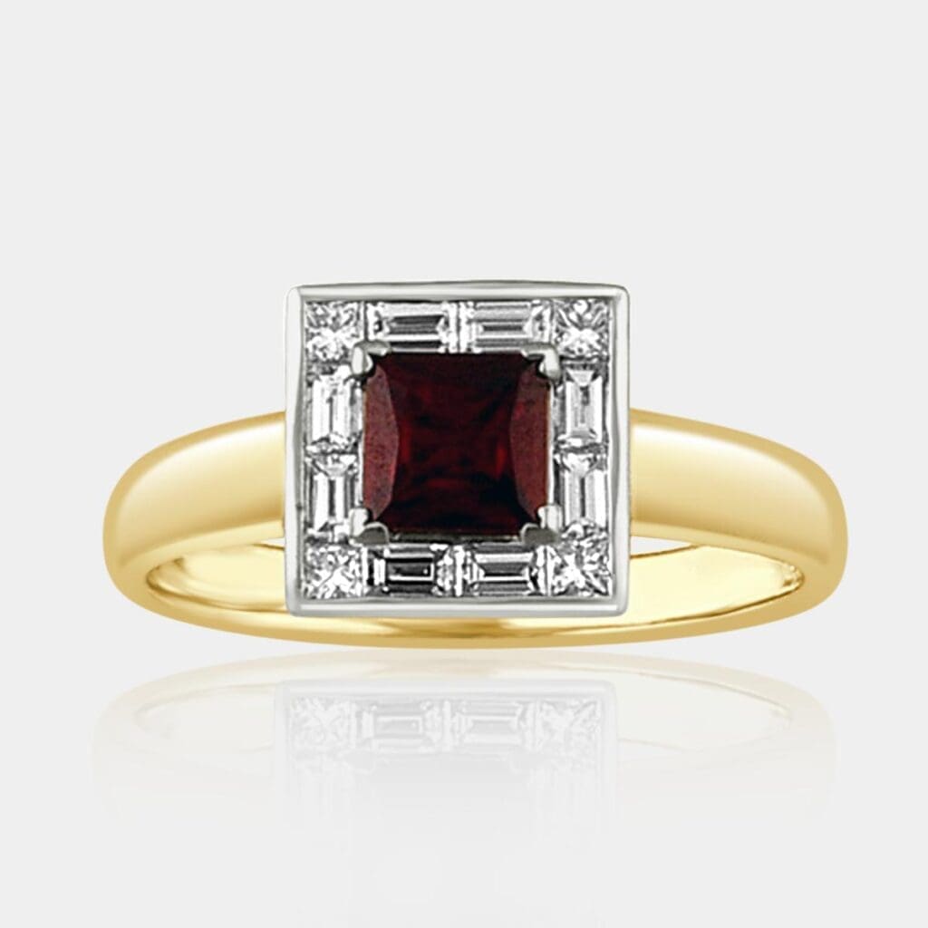 Two-tone gold ring featuring princess cut ruby with square halo of surrounding princess cut diamonds and baguette cut diamonds.