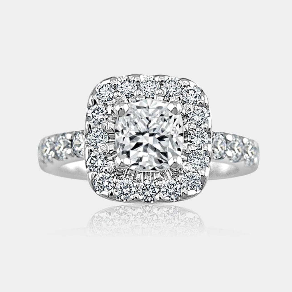 Cushion cut diamond centre with surround and shoulder diamonds.