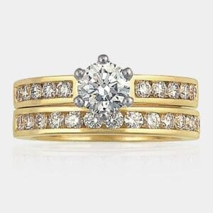 0.65 carat Round brilliant cut diamond engagement ring with channel set shoulder diamonds, with matching wedding ring in 18ct yellow and white gold.